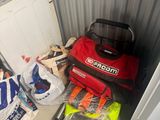 un sac rouge posé par terre à côté d'une pile d'objets