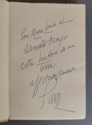 un livre ouvert, sur lequel est inscrit un poème manuscrit, posé sur une table