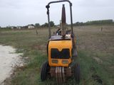 un tracteur jaune qui est garé dans l'herbe