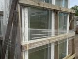 a stack of windows sitting on a pallet in front of a building