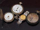 quatre types différents de montres de poche posées sur une table