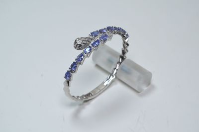 Un jonc ouvrant en argent, serti de 6 cts env de tanzanites …