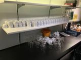 many cups and glasses on the counter in the kitchen