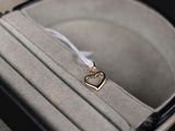 une valise dans laquelle se trouve un pendentif en forme de cœur doré