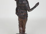 bronze statue of a woman holding her hand up in the air