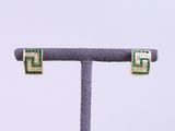 pair of gold and green earrings with diamonds on a stand