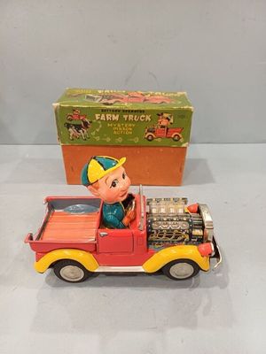 un vieux camion en fer-blanc avec un petit garçon à l'arrière