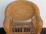 a wicker chair that is sitting on a black rug