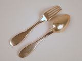 deux cuillères et une fourchette en argent sur une table
