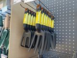 a lot of gardening utensils hanging on the wall