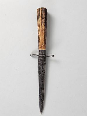 un couteau avec un manche en bois sur une surface blanche
