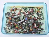 a plastic container filled with assorted toys on a white surface