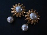 pair of gold tone earrings with pearls and sunbursts