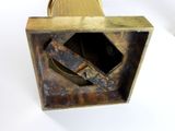 a metal object with a hole in it on a white surface