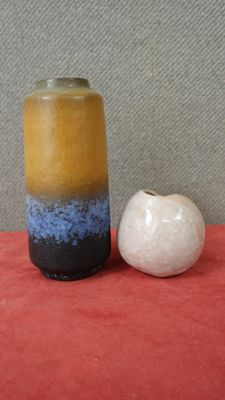 deux vases posés l'un à côté de l'autre sur une surface rouge