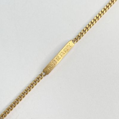 Gros plan sur un bracelet en or orné d'une barre