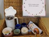 un panier en osier rempli de tasses à café et d'un petit mot