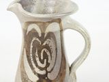 a brown and white pitcher with a heart on it