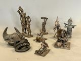 Plusieurs figurines de types et de tailles variés sont exposées sur une table