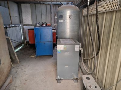 un chauffe-eau installé dans un garage, contre un mur