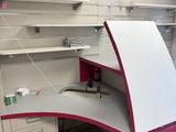 a pink and white desk in the corner of a room