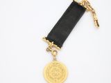un gros plan d'une médaille d'or suspendue à un ruban noir