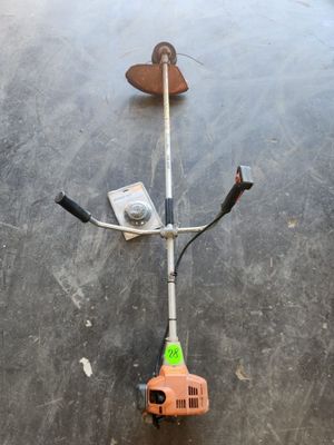 une photo d'une débroussailleuse posée sur un sol en béton