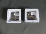 two white boxes with screws in them on a table
