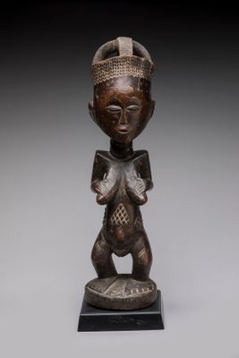 une statue en bois d'une femme avec un chapeau sur la tête