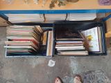 une personne debout devant une table couverte de livres