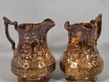 pair of antique brass pitchers with blue and gold designs