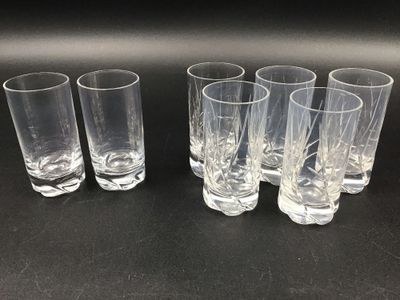 six verres à shot transparents alignés sur une surface noire