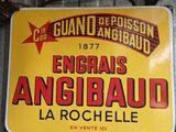 panneau jaune et rouge accroché à un mur métallique dans un garage