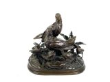 statue en bronze représentant un oiseau perché sur une branche d'arbre, sur fond blanc