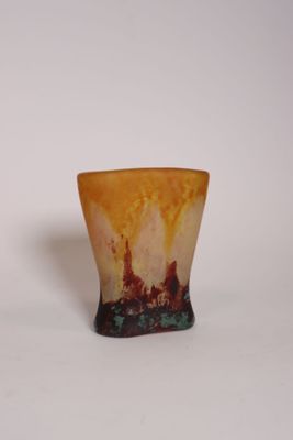 un petit vase posé sur une surface blanche