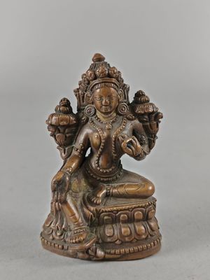 une statue en bronze représentant une femme assise sur une table