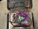 une boîte à outils posée par terre, contenant quelques fils électriques