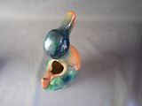 a ceramic bird that is sitting on top of a vase