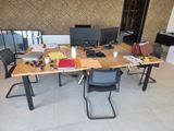 une table en bois sur laquelle sont posés deux écrans d'ordinateur