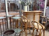 tables and chairs in a room with large windows and a bar