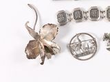 a lot of silver jewelry on a white surface