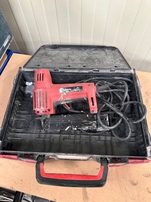 a tool box with a corded drill and other tools on a table