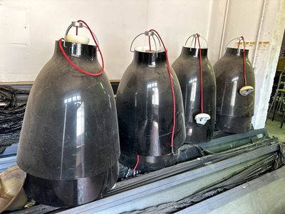 four large black tanks sitting on a table