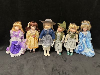 sept poupées en porcelaine représentant des enfants vêtus de tenues et de chapeaux variés