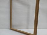 an empty mirror sitting on top of a table next to a white wall