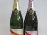 two bottles of champagne sitting next to each other on a table