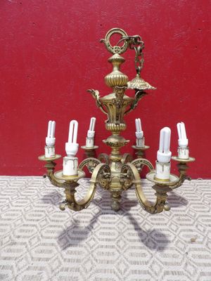 un lustre ancien en laiton à cinq bougies posé sur une table