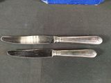 two knives that are sitting next to each other on a table