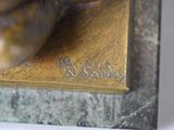 a bronze statue of a bird on a base