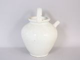 a white vase with a handle sitting on a table